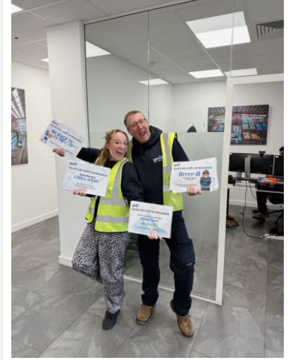 Two Igloo team members in hi-vis holding the new delivery-in-progress signs